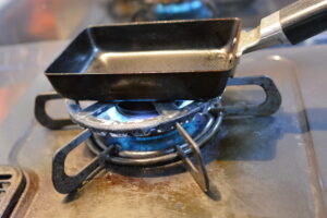 alt="卵焼きを焼いている途中の様子｜フライパンで巻いている工程"